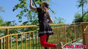 A beautiful girl with glasses walks and seduces people in the park with her look