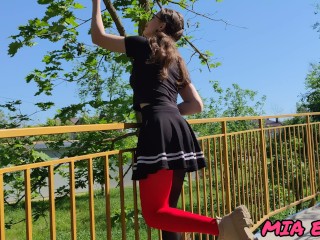 A beautiful girl with glasses walks and seduces people in the park with her look