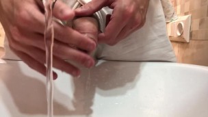 Gay stud twink pissing in a sink with a hard uncut dick