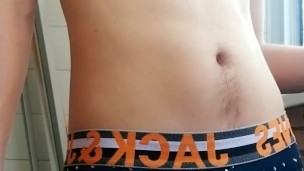 a guy with a beautiful body and a big dick in panties smokes on the balcony