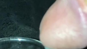Super close up slow motion trying to cum into shot glass