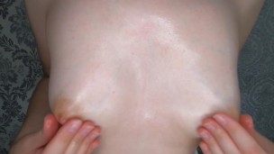 titted brunette rubs nipples with oil and plays with them