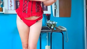 An elegant lady employee in red lingerie undresses in the office. Camera 2