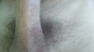 The guy jerks off on the bed and cums on himself