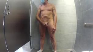 Naked in public restroom with earplugs in so I can't hear and jacking off with mask over eyes.