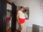 A naked lady does make-up in front of a mirror, puts on underwear, stockings, a skirt. 3 7/16