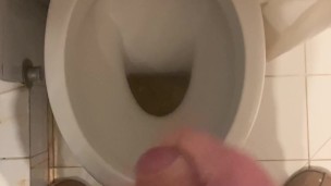 a guy pisses and then masturbates in the bathroom, cumming with his nice cock all over the place