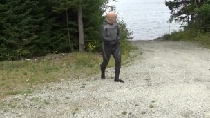 wetsuited silicone masked man on patrol near lake