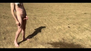 The hairy guy shoots a tight stream of piss high on the field. Man pissing in nature