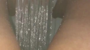 Girl pisses in a stream of water in the shower
