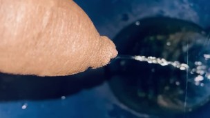Pissing into bathroom commode 