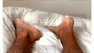 Boys feet waking up in white bedding 