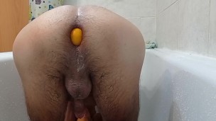 Mulat fucks himself in the ass with a dildo with tangerines