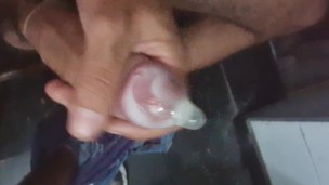 Batendo punheta de camisinha e enchendo ela de porra