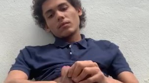 Latino teen rubs his knit shorts and polo