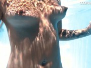 Her body cutting through the shimmering water of the pool 13/16