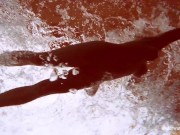 In the indoor pool, a stunning girl swims 15/16