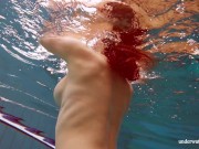 In the indoor pool, a stunning girl swims 9/16