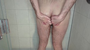 Caged cuckold takes out large butt plug in the shower