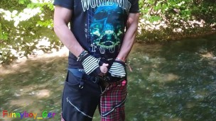 German guy stands in a creek, pisses and jerks off his hard cock