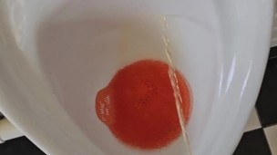 Pissing in a public urinal toilet