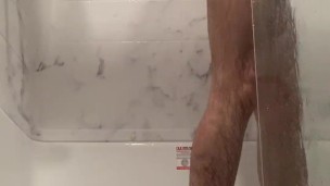 Hot guy cleans himself in the shower.