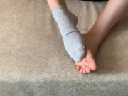 The girl her legs and takes off her socks with her feet 13/16