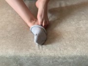 The girl her legs and takes off her socks with her feet 15/16