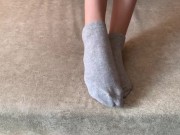 The girl her legs and takes off her socks with her feet 2/16