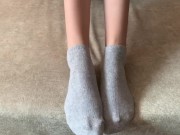 The girl her legs and takes off her socks with her feet 4/16