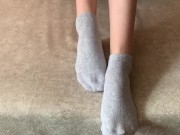 The girl her legs and takes off her socks with her feet 6/16