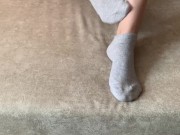 The girl her legs and takes off her socks with her feet 8/16