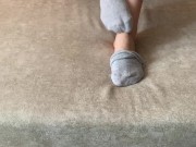 The girl her legs and takes off her socks with her feet 9/16