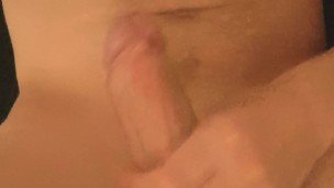 naked man masturbates his cock on the bed