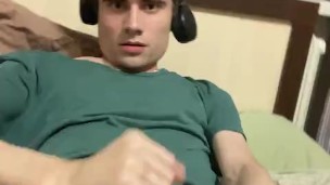 A guy jerks off in a green T-shirt and cums with sperm on the T-shirt