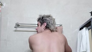 Guapo flexionando músculos en el baño, verga grande