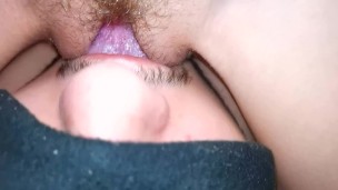 The wife moans from cunnilingus, close-up, sitting on her face with a wet pussy.
