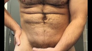 Hairy muscle stud flexing and stroking cock in public restroom