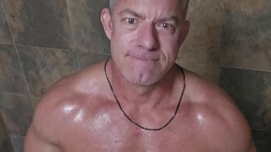 Stud rubs down with oil before practicing throating a cock in the shower