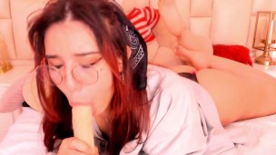 Anime girl in glasses looks adorable while sucking a rubber cock for you