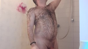 Hairy bear washes himself in the shower