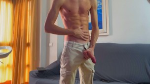 Joven delgado se corre con los jeans puestos
