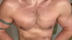 Bearded jock flexes in bathroom