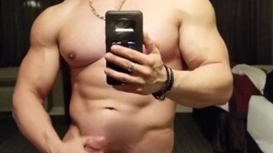 Big muscled hunk cums in front of mirror