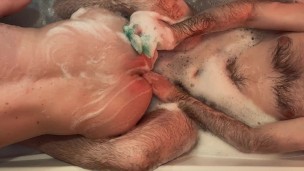 Two hairy guys caress each other in a bubble bath, do feet massage, piss and cum from handjob