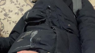a boy jerks off his dick in a winter jacket and a hat, lighting a lighter and cumming with a fountai