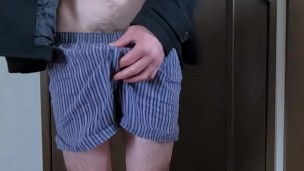 An exhibitionist masturbates while wearing a coat and underpants.