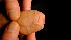 Very Close up on the tip of his uncut penis as he plays with his foreskin and show bell-end