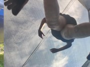 Tall girl in shorts jumping barefooted on a trampoline (slowed down) bottom view 11/16