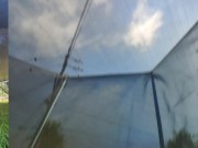 Tall girl in shorts jumping barefooted on a trampoline (slowed down) bottom view 12/16